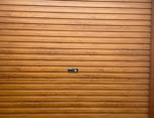 wooden panel garage door with black locking handle