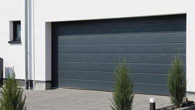slate coloured sectional garage door built into white house