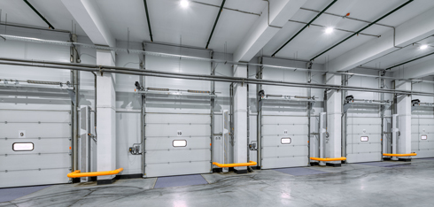 inside industrial warehouse line of garage doors and loading bays with yellow bars